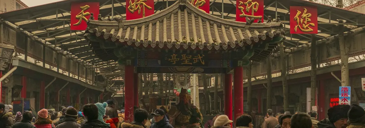 Visitors passing under a traditional Chinese gate