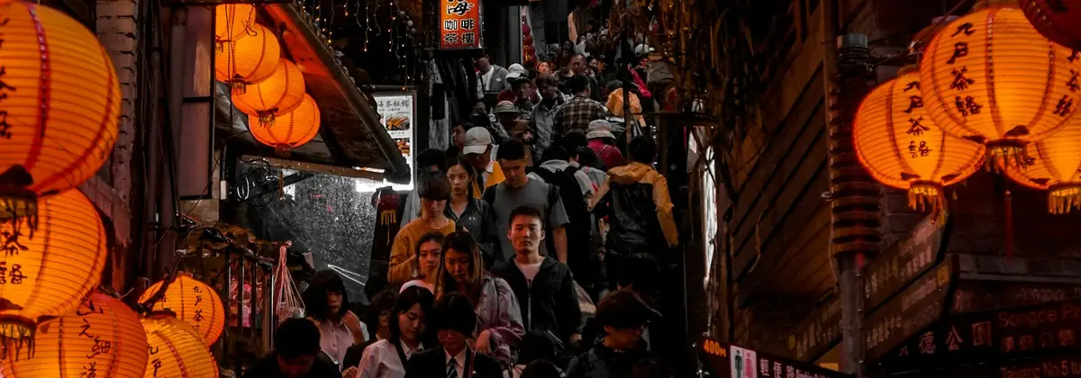 Crowds under red lanterns at a Taiwanese night market