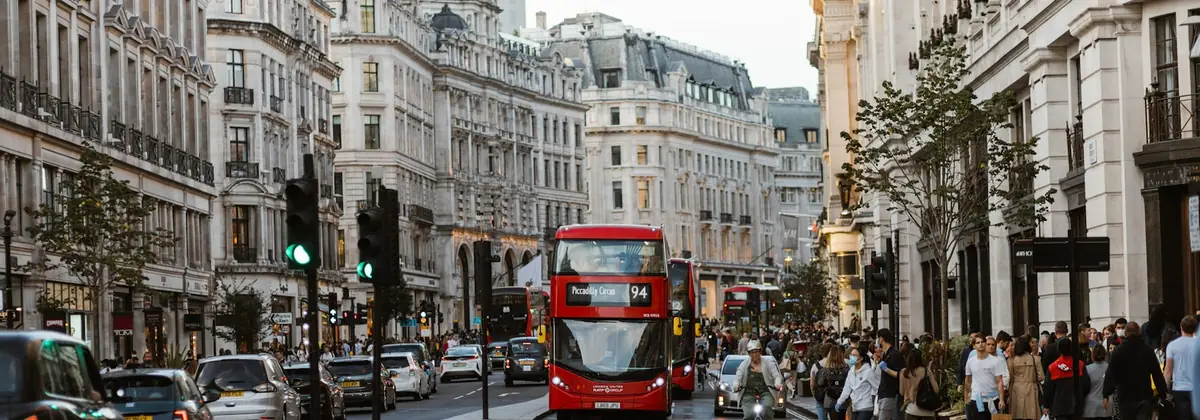 A red double-decker bus and pedestrians in London