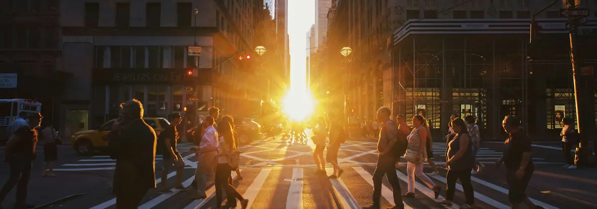 Pedestrians crossing a New York street at golden hour